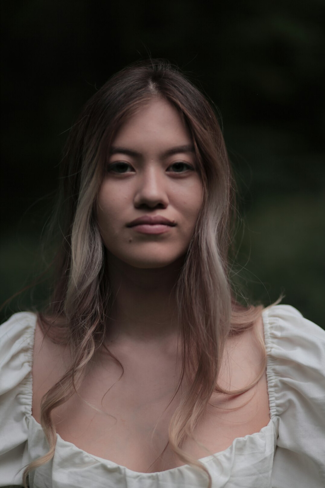 Portrait of a young woman with dark shoulder-length hair and a cream blouse