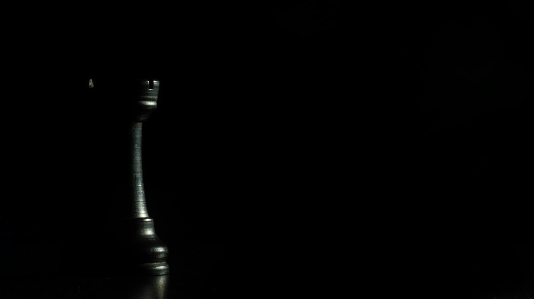 Vintage microphone on a stand in a single spotlight on a dark stage